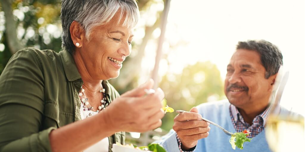 Aging couple eating a nutrient-dense diet, including salad