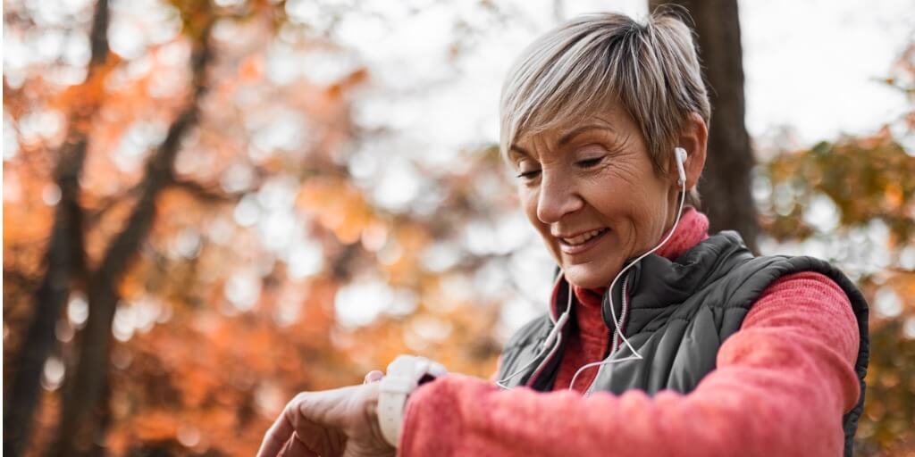 Woman looking at her smart watch while on a run