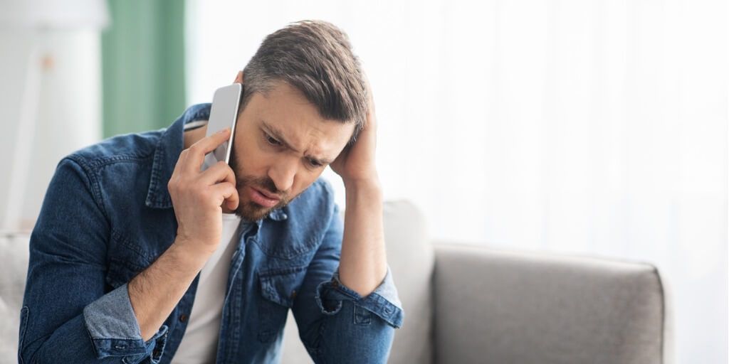 Middle-aged man trying to schedule a specialist appointment over the phone