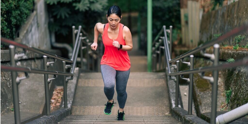 Woman running up a set of stairs for cardiovascular exercise