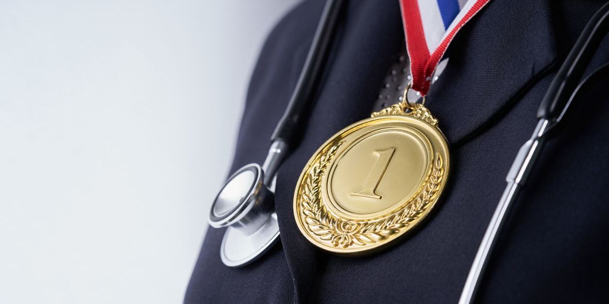 Healthcare personnel with winning medal.