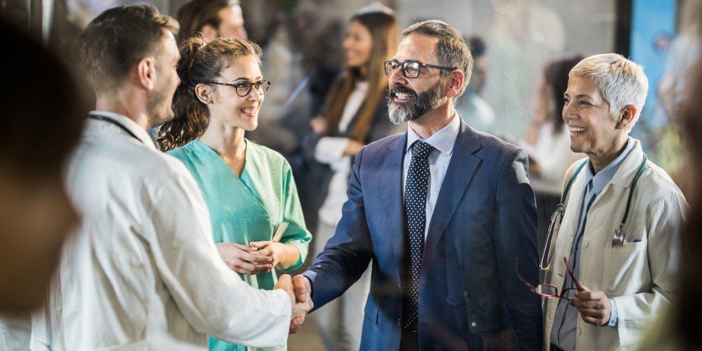 Doctor shaking hands with an executive health patient. 