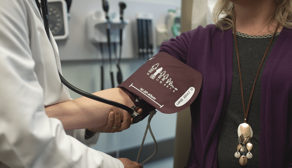 Physician taking blood pressure of patient