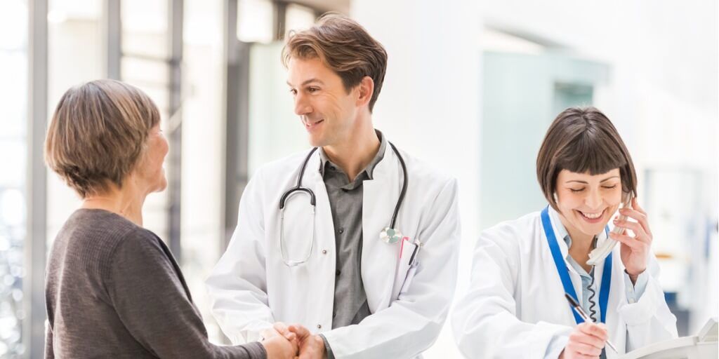 Male physician shaking hand of new patient