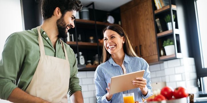 Happy couple cooking in kitchen