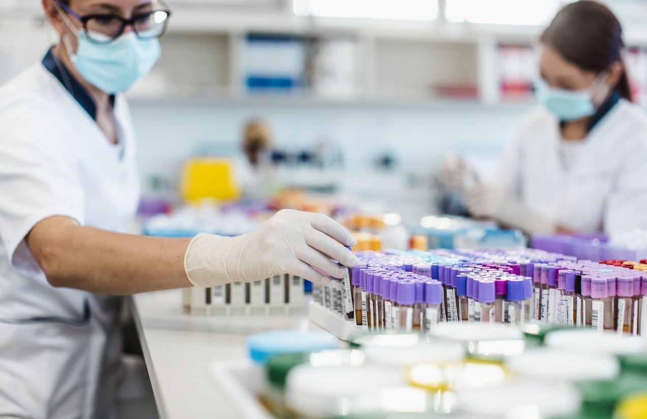Woman checking blood test vials.